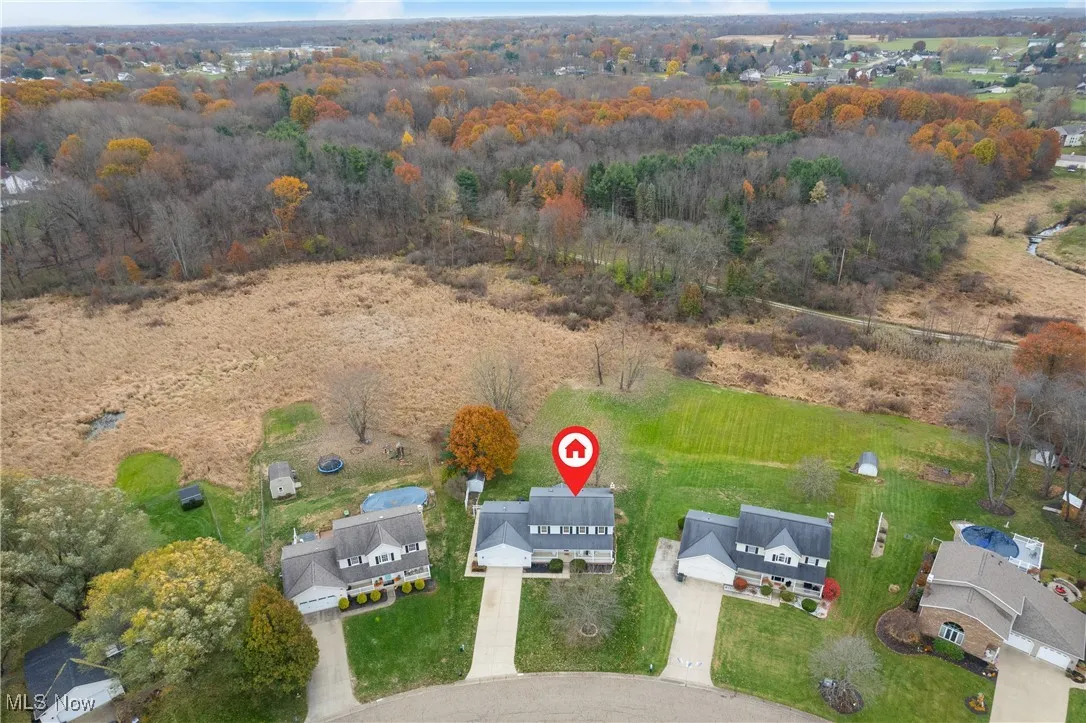 Aerial view of property and surrounding area featuring nearby suburban area