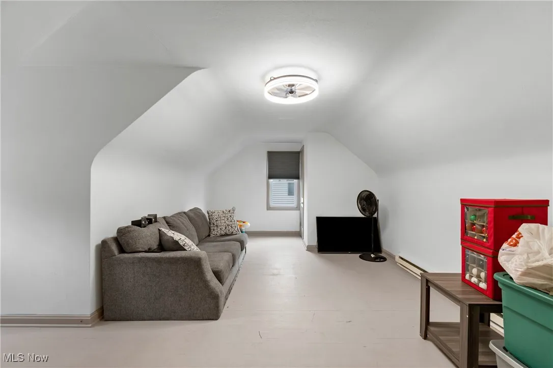 Additional living space featuring lofted ceiling and a baseboard heating unit