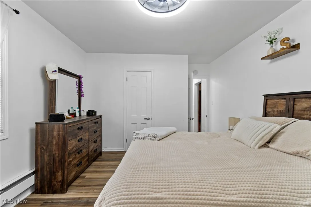 Bedroom featuring a baseboard radiator and wood finished floors