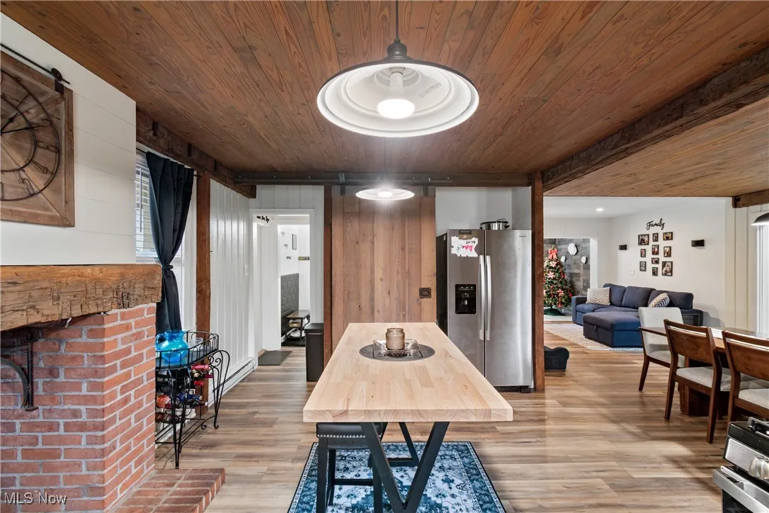 Dining space with light wood-type flooring, wood ceiling, and wood walls