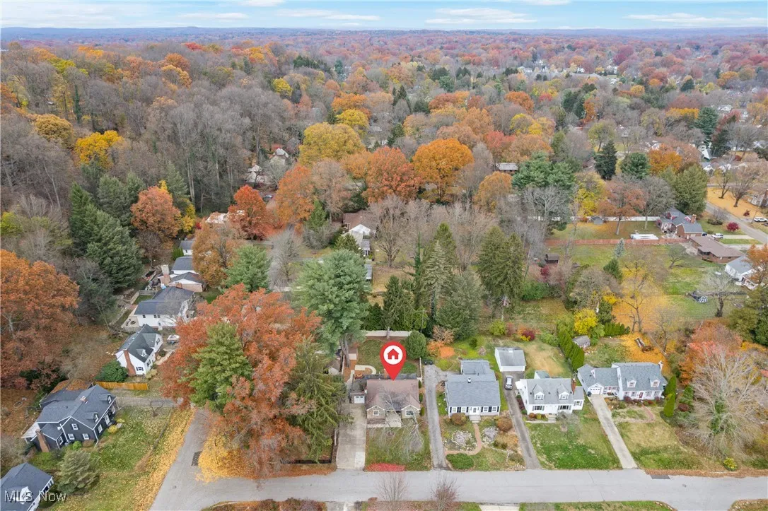 Aerial view of property's location with nearby suburban area and a forest