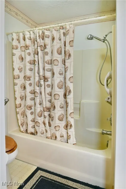 Bathroom featuring shower / bath combo with shower curtain and toilet
