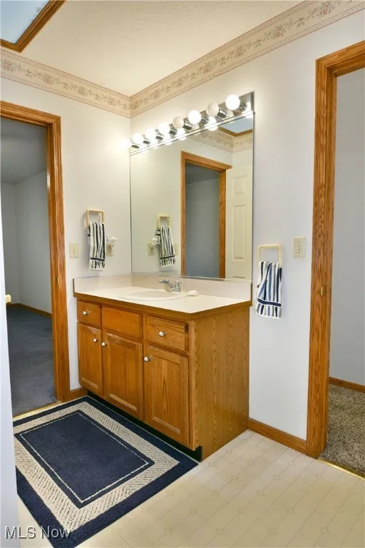 Bathroom with vanity and crown molding