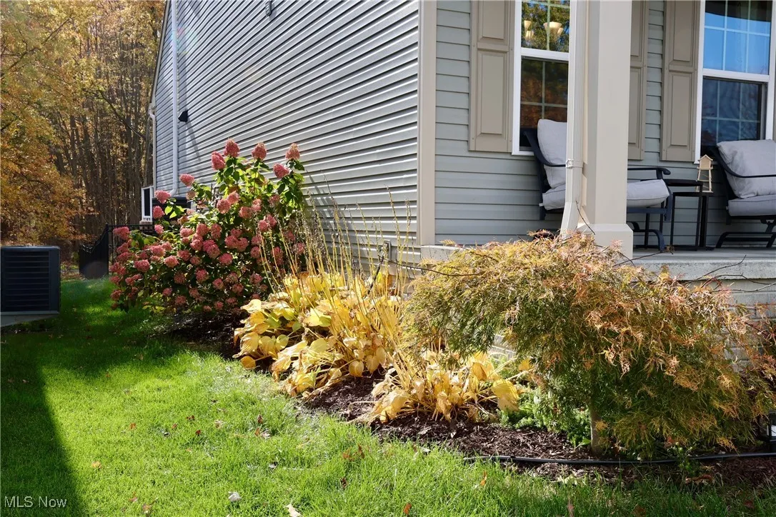 View of home's exterior with a lawn and a cooling unit