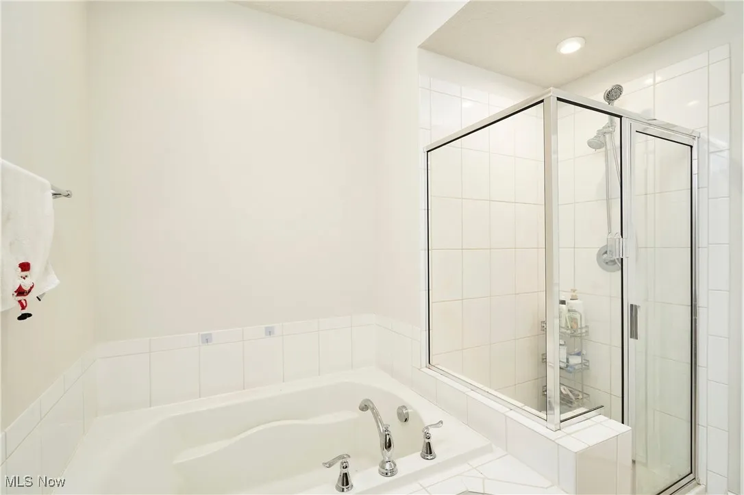 Full bathroom with a garden tub and a stall shower