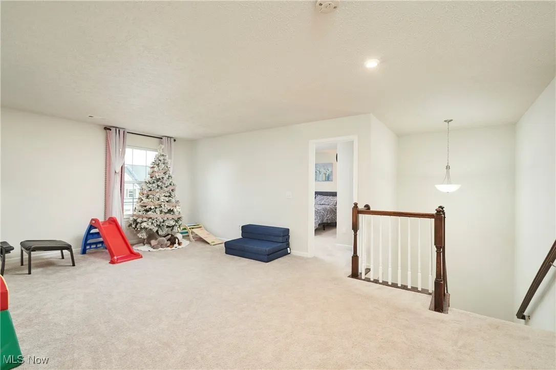 Playroom with carpet and a textured ceiling