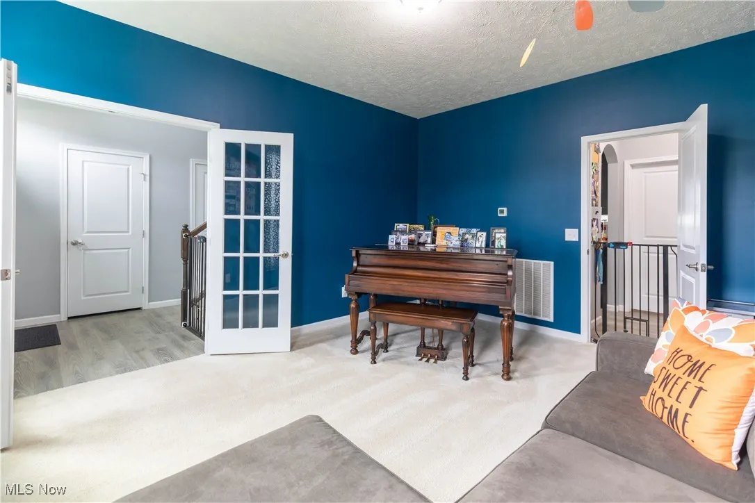 Living area featuring light carpet and a textured ceiling