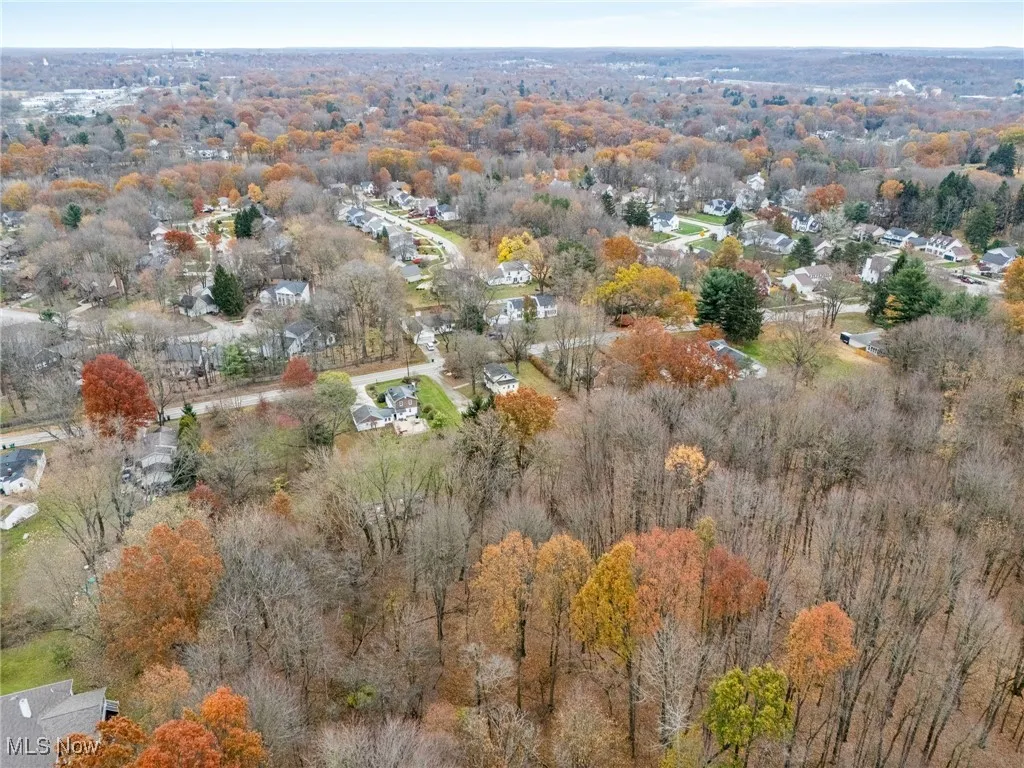 Aerial view of property and surrounding area featuring nearby suburban area