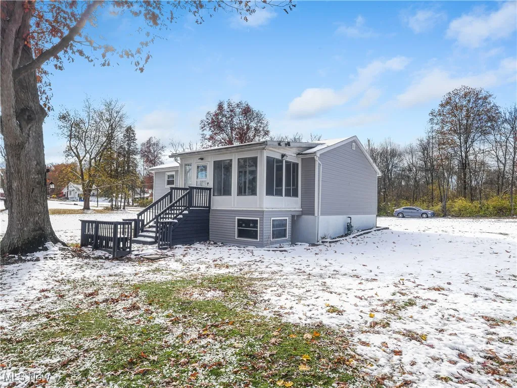 Snow covered house with a sunroom
