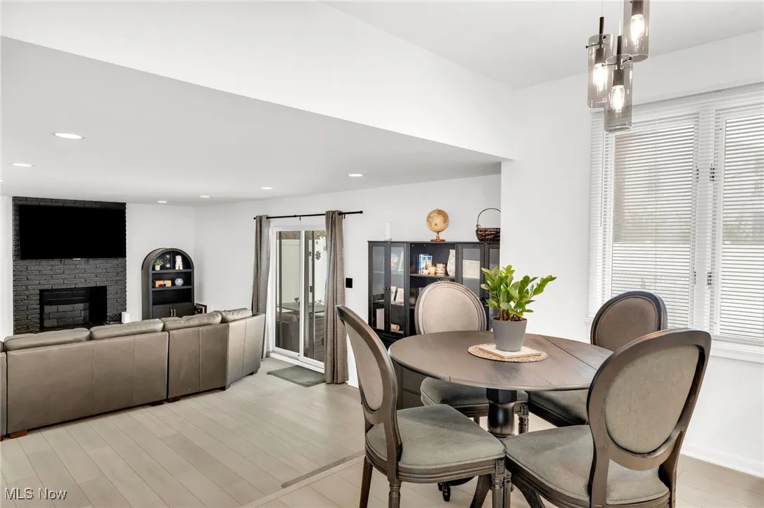 Dining space with a fireplace, light wood-style flooring, and recessed lighting