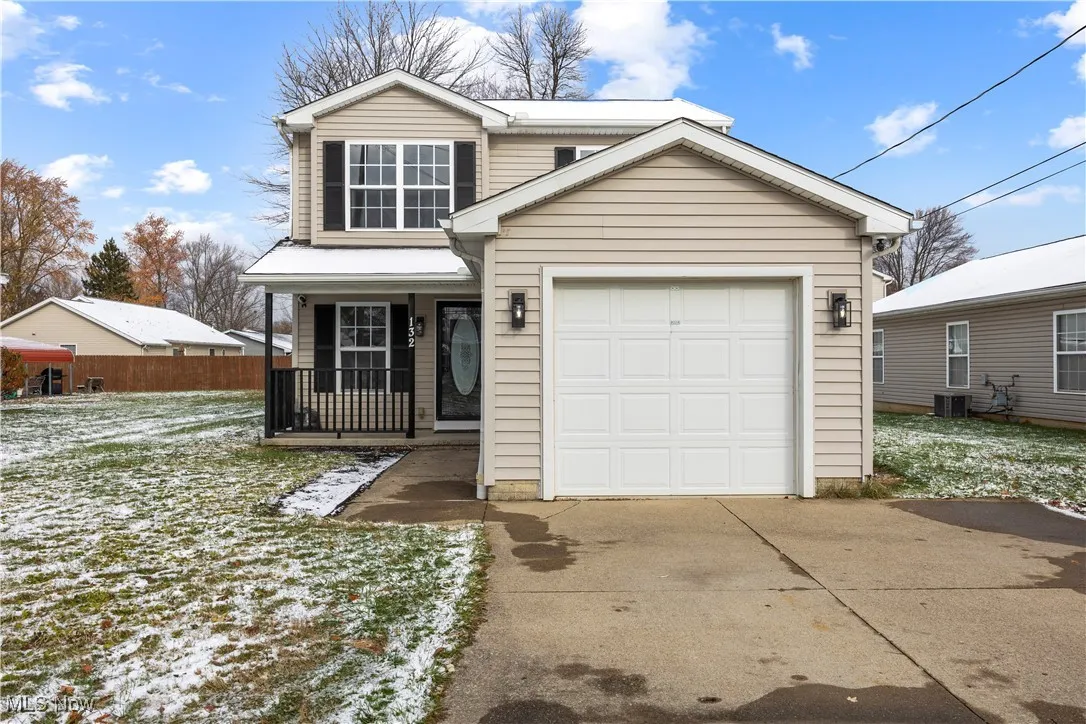 Traditional-style house with driveway and covered porch