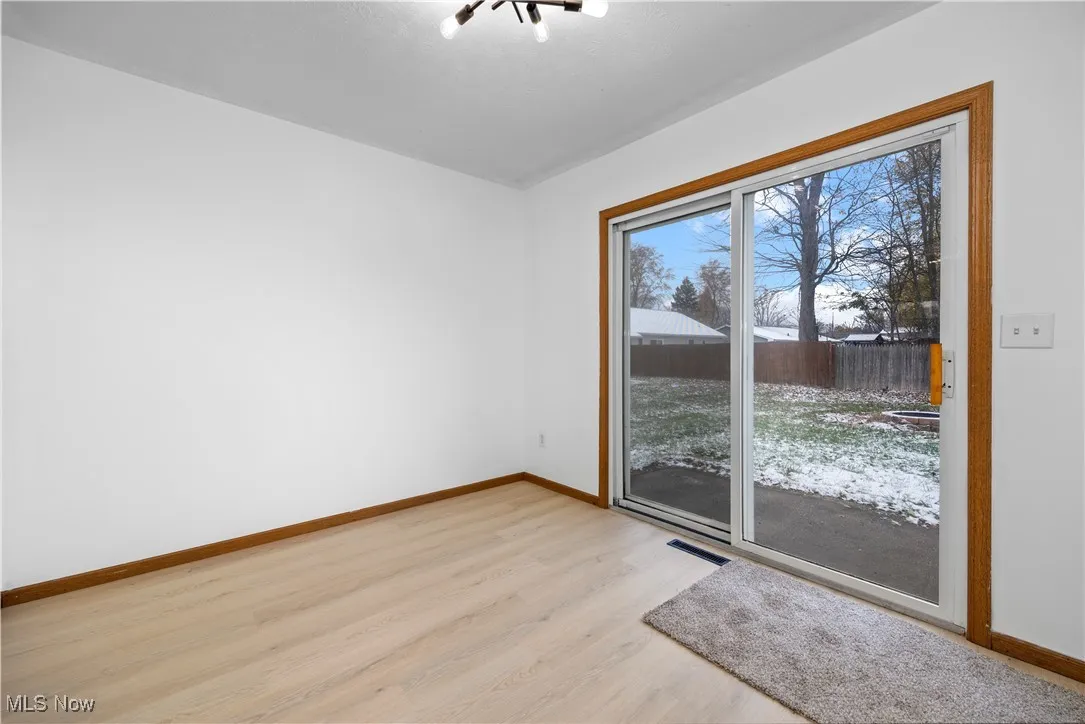 Empty room featuring light wood finished floors and a chandelier