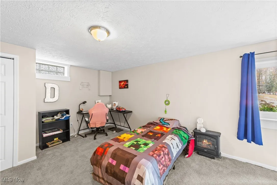 Bedroom featuring multiple windows, light carpet, and a textured ceiling