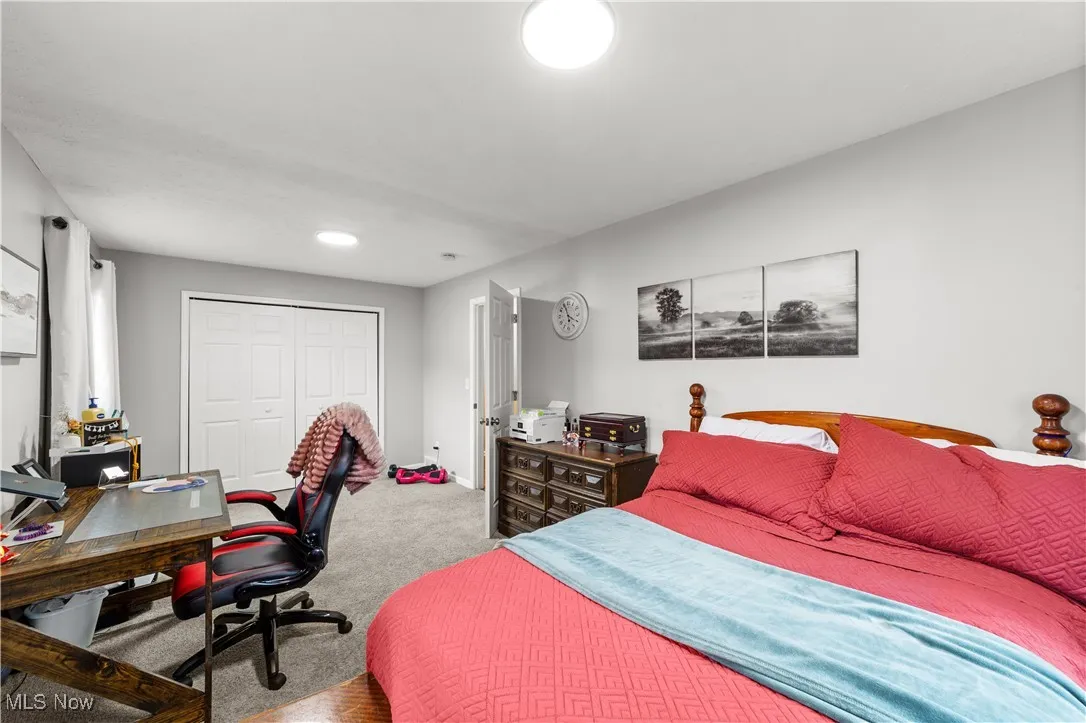 Bedroom featuring an office area, a closet, and carpet floors