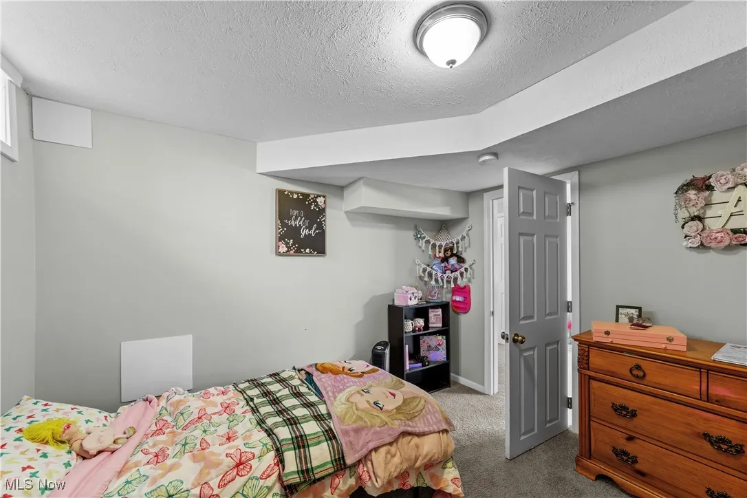 Bedroom featuring carpet floors and a textured ceiling