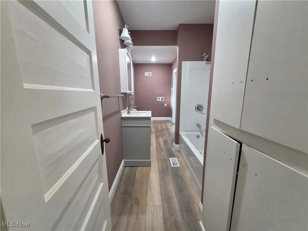 Full bath with vanity, tub / shower combination, and dark wood finished floors