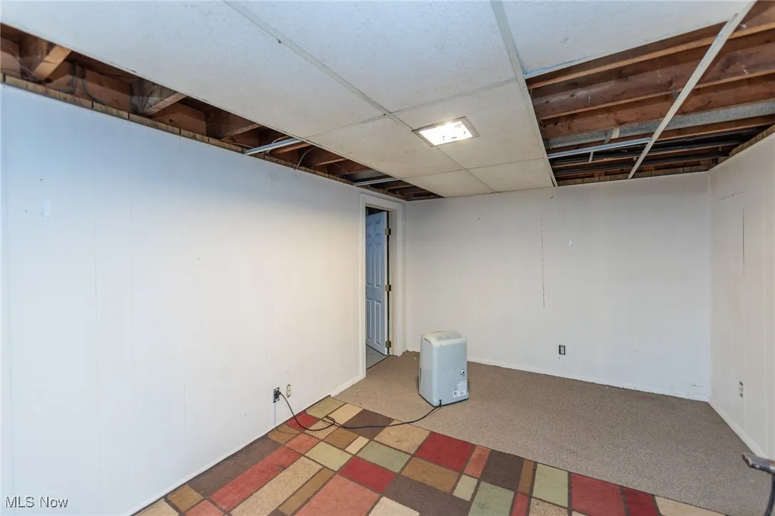 Finished below grade area with carpet floors and a drop ceiling