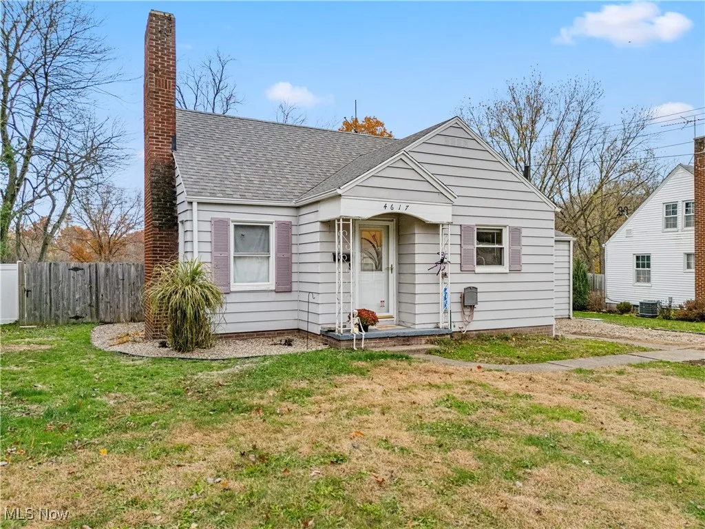 Bungalow-style home featuring roof with shingles and a chimney