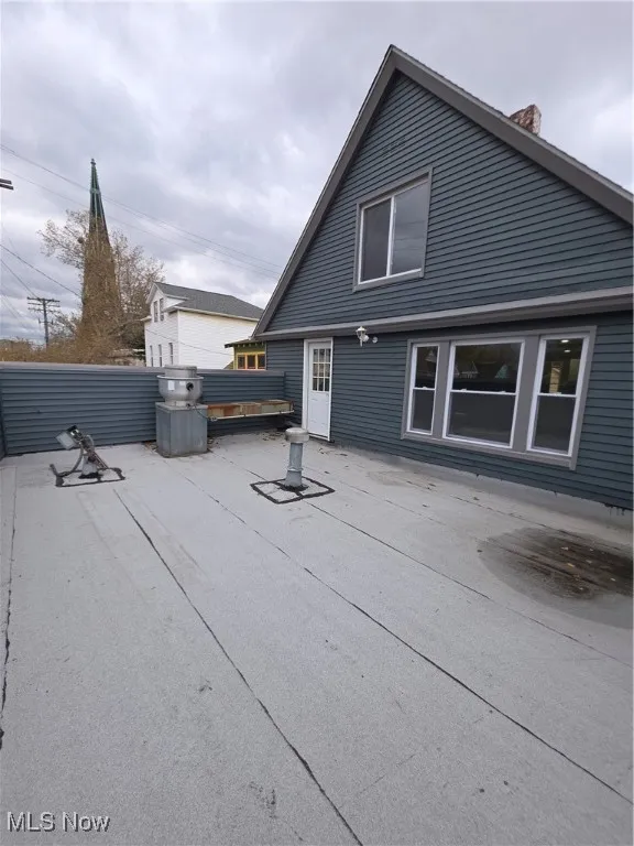 Rear view of house with a chimney and a patio