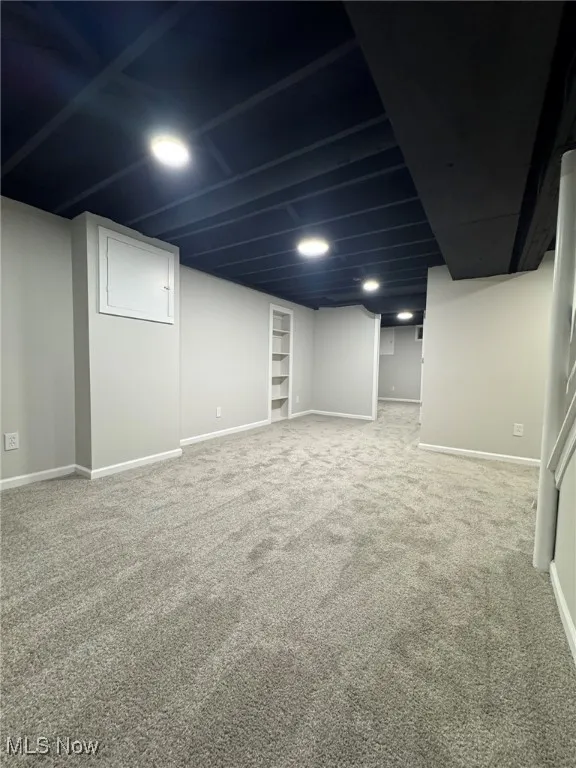 Finished basement featuring baseboards and light carpet