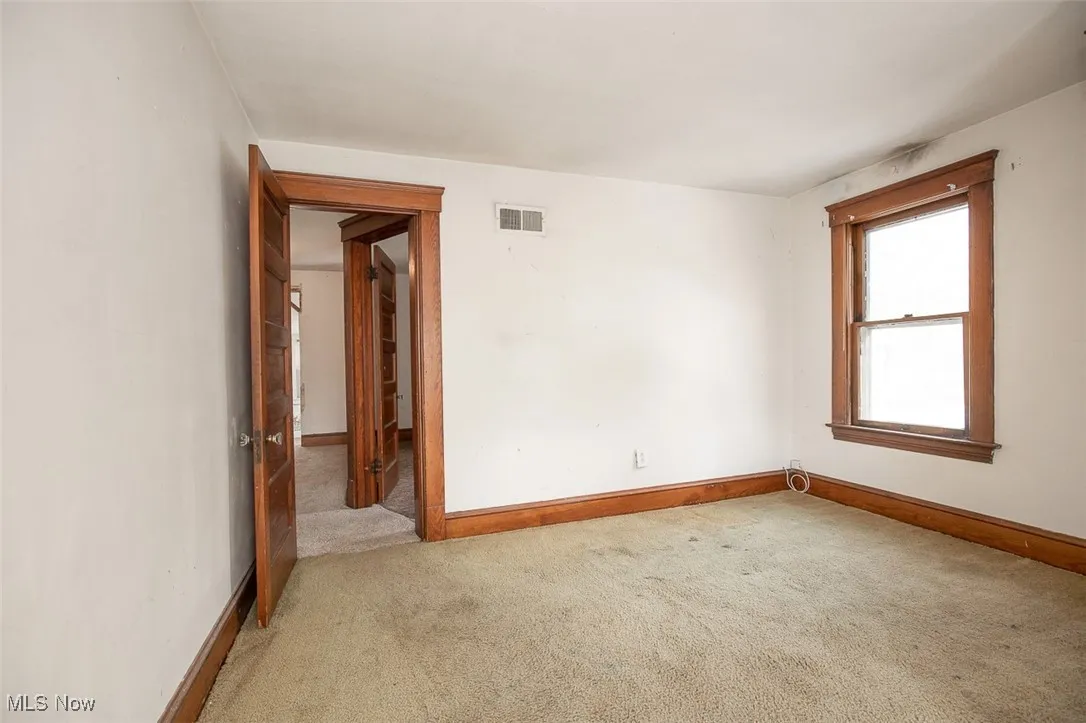 Spare room featuring light carpet and baseboards