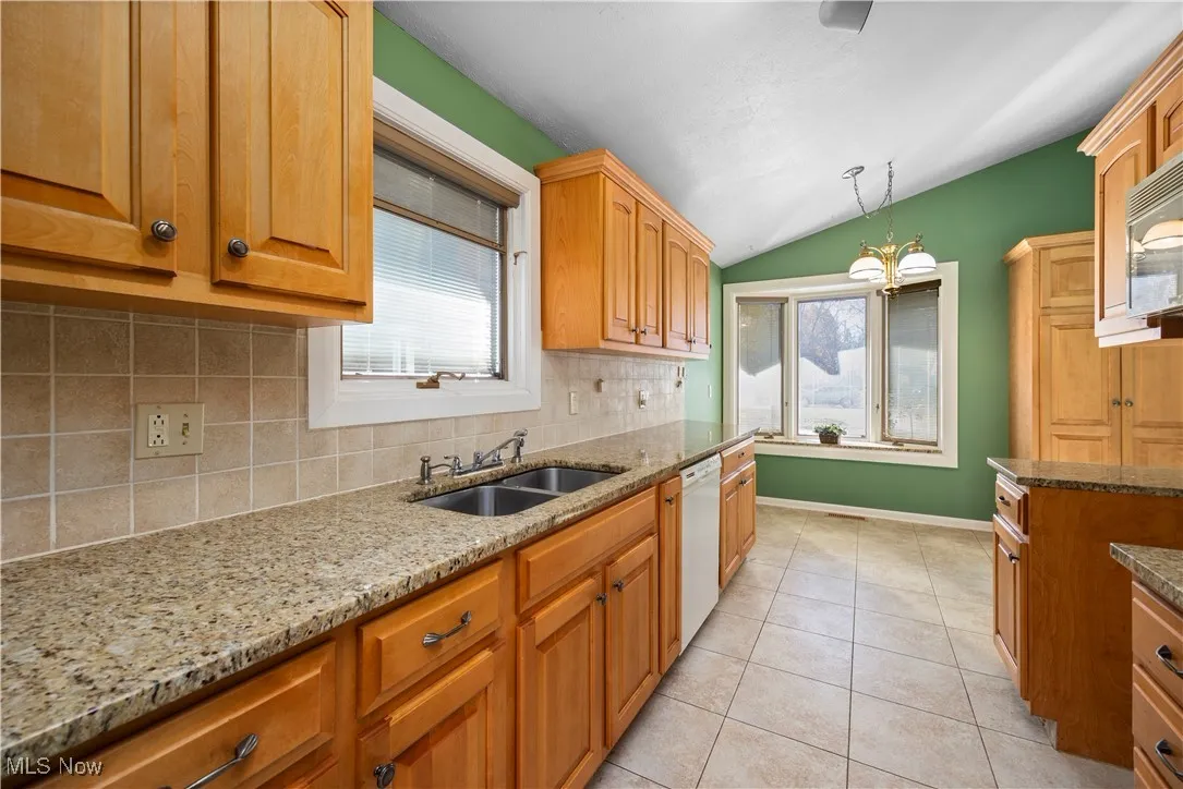 Kitchen featuring backsplash, lofted ceiling, light tile patterned floors, plenty of natural light, and pendant​​‌​​​​‌​​‌‌​‌‌​​​‌‌​‌​‌​‌​​​‌​​ lighting