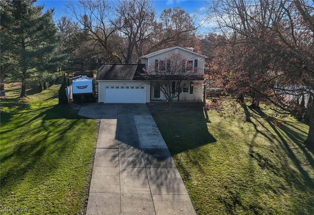 Traditional home featuring concrete driveway, a front yard, and an attached garage