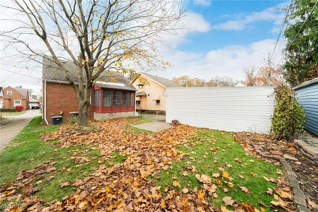 Back of property with a sunroom, a patio area, and brick siding