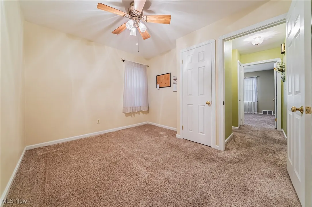 Unfurnished bedroom with carpet floors and a ceiling fan