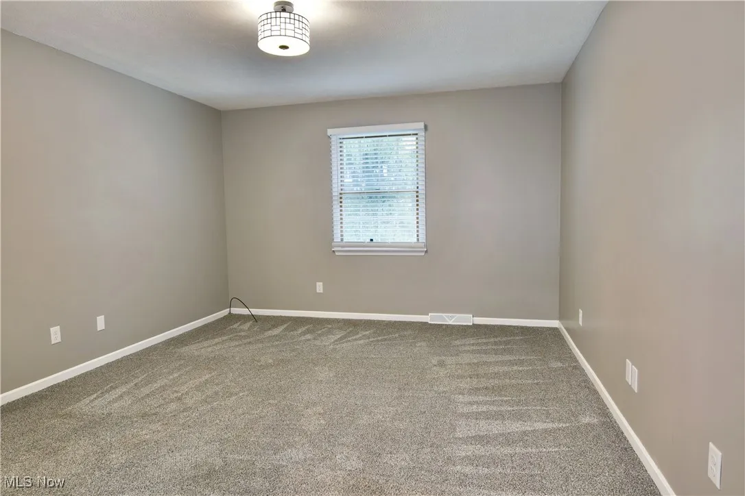 Unfurnished room with carpet floors and baseboards