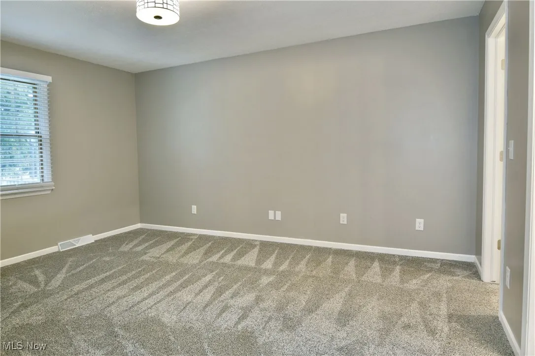 Empty room with carpet floors and baseboards