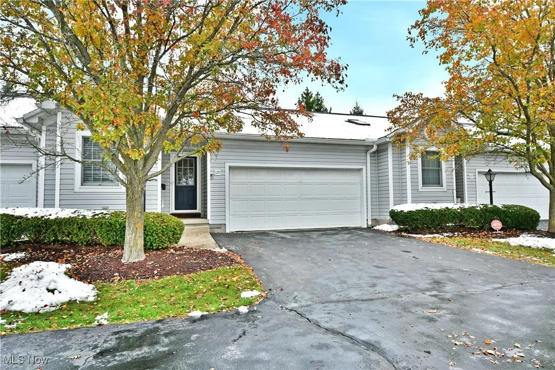 View of front facade featuring asphalt driveway and an attached garage