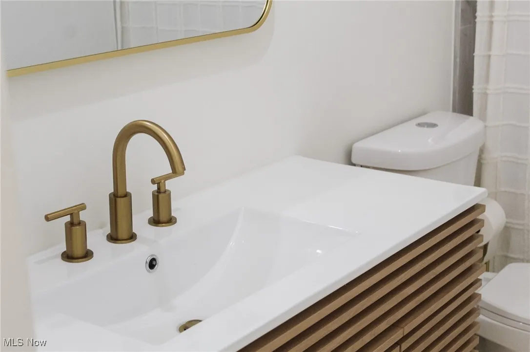 Full bath with a shower with curtain and vanity