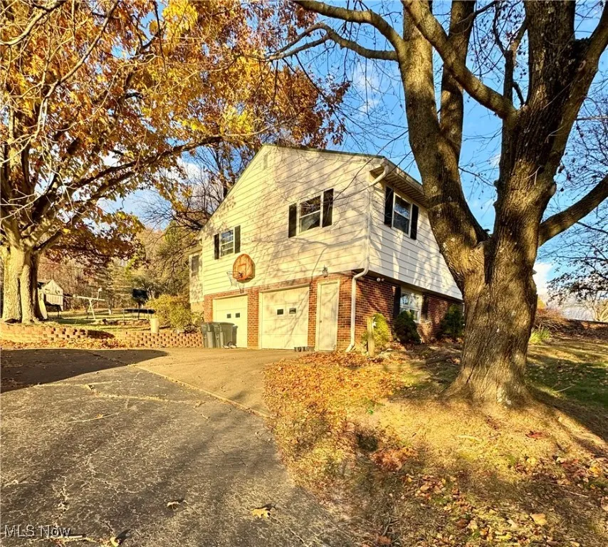 View of home's exterior featuring brick siding, driveway, and an attached garage