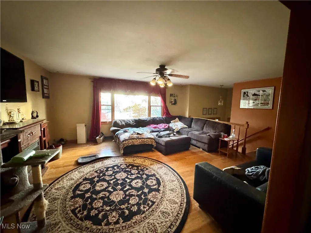 Living room with light wood-style flooring and ceiling fan