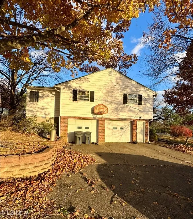 View of home's exterior featuring brick siding, a garage, and concrete driveway