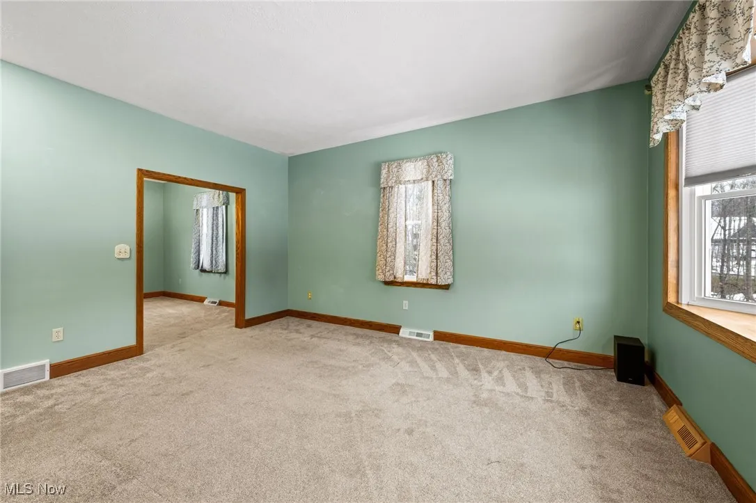 Carpeted empty room with baseboards