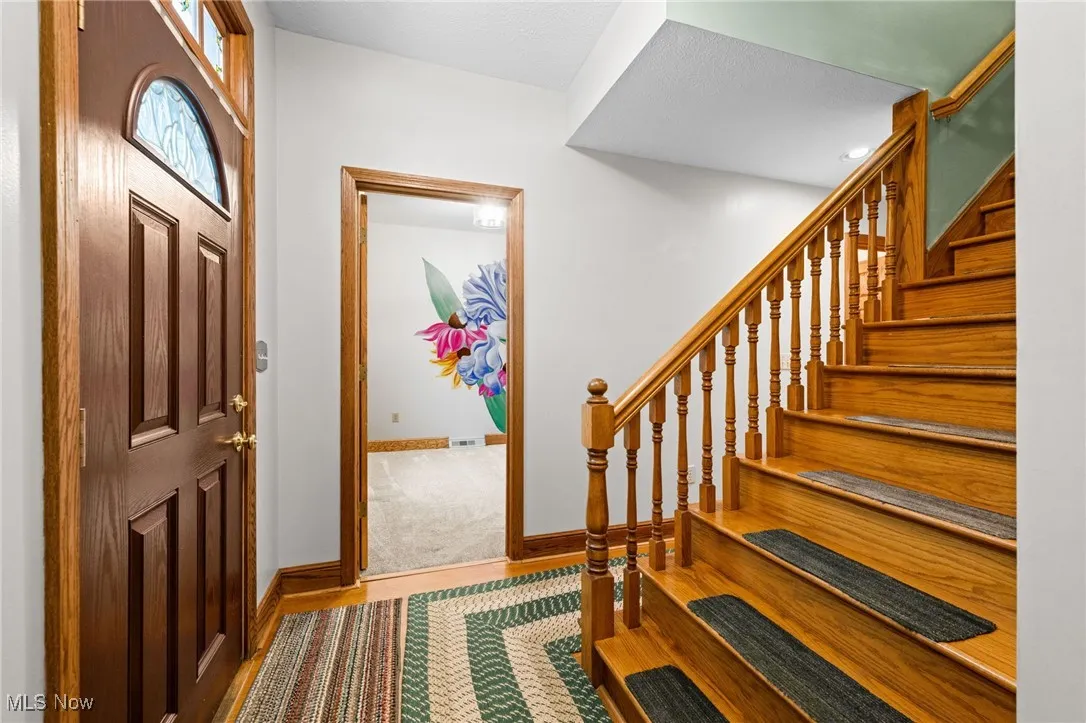 Entryway with stairs and wood finished floors