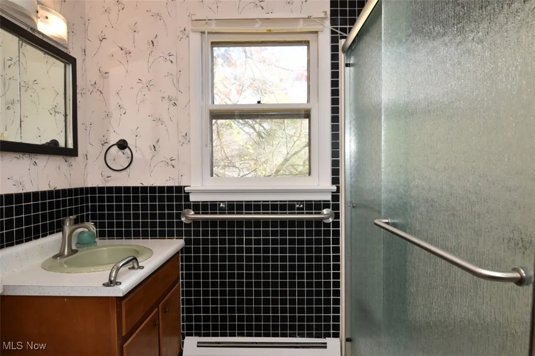 First floor full bathroom attached to the den/office/5th bedroom with two large closets, low entry shower, new faucet, shower glass door and light.