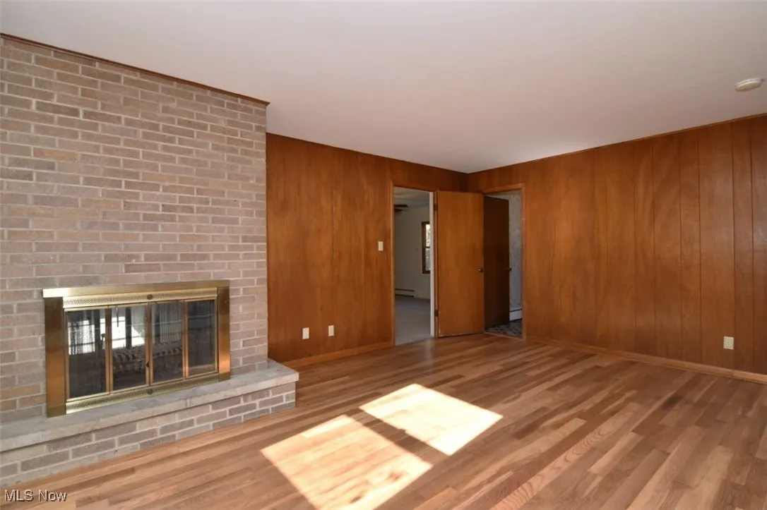 First floor office/den/could be 5th bedroom, in law or teen suite. Gorgeous hardwood floors just refinished! WBFP. Full bath attached through doorway in the middle of the photo. That leads to a hallway where the 2nd exterior rear entrance is as well as full bath with low entry shower.