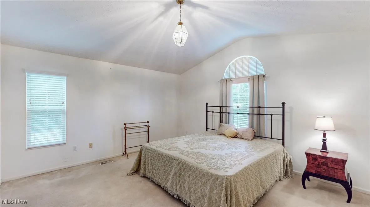 Spaciously appointed Master Bedroom w/Vaulted Ceiling & chandelier*Carpeted w/blinds on windows