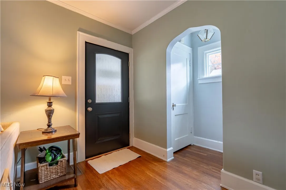 Entrance foyer featuring arched walkways and crown molding.