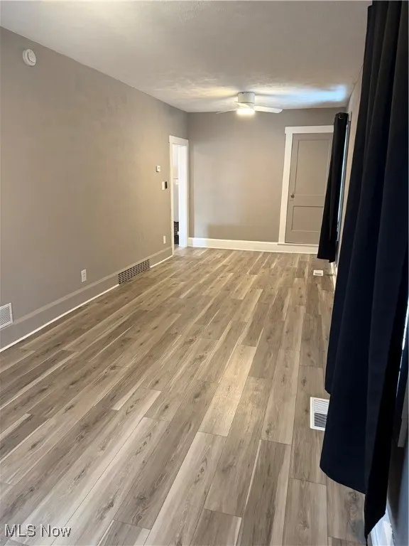 Spare room featuring light wood-style floors and baseboards
