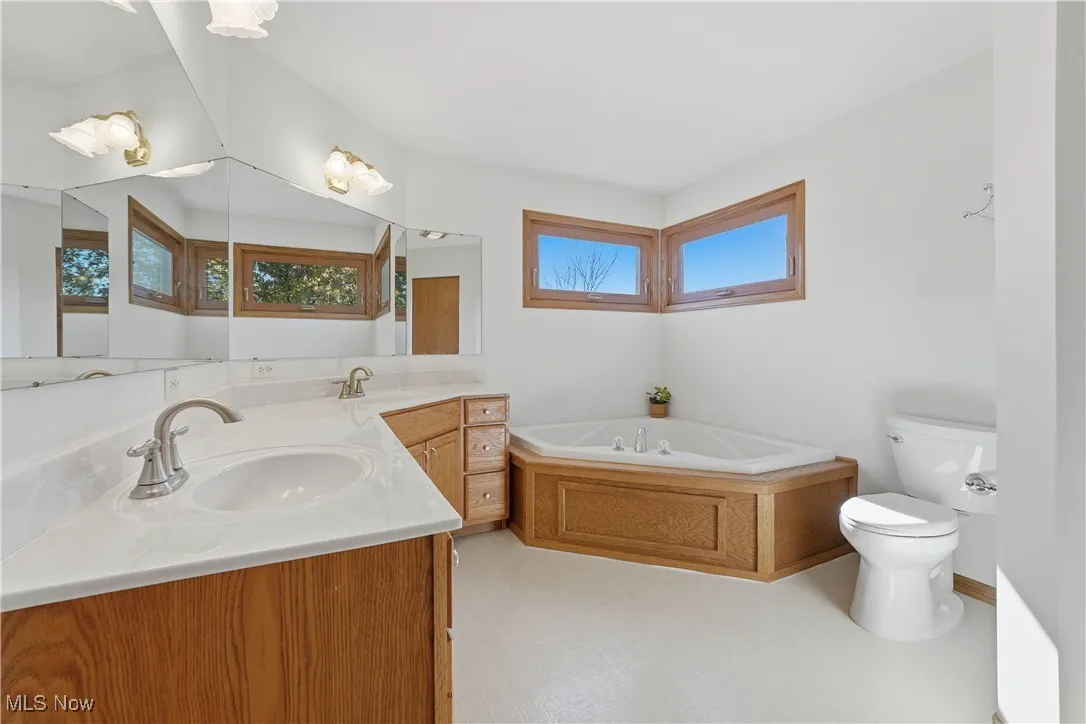 Full bathroom featuring double vanity and a garden tub