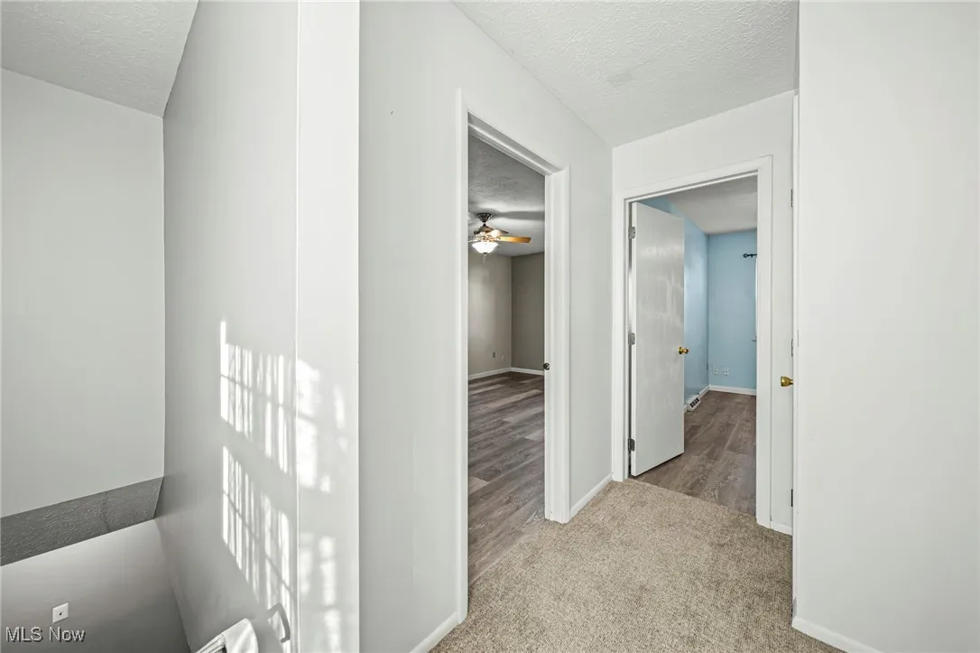 Hall with a textured ceiling and light carpet
