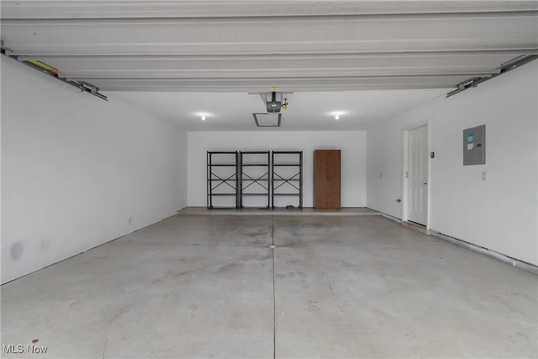 Clean, attached 2-car garage—includes sturdy storage shelving, attic access for seasonal items, automatic opener, and direct entry to the home for everyday convenience.