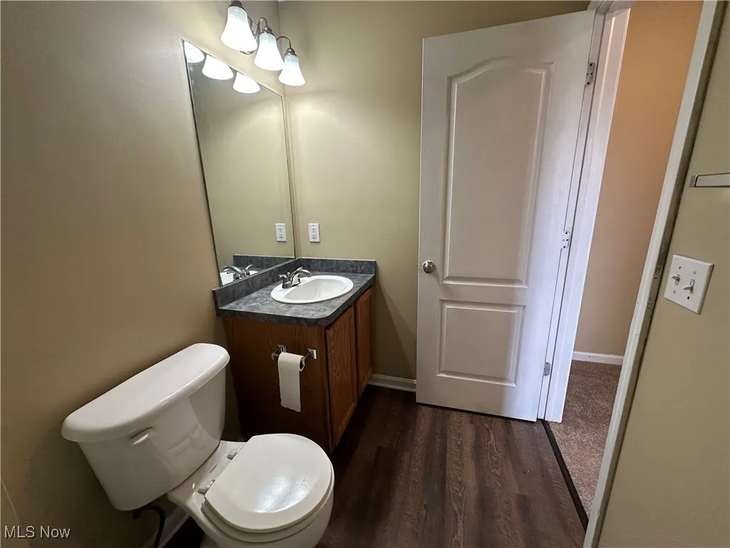 Half bath featuring dark wood finished floors and vanity