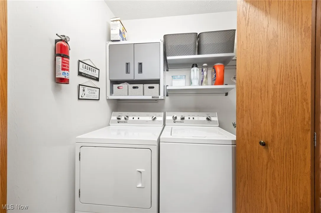 Laundry room with washer and clothes dryer and a textured ceiling