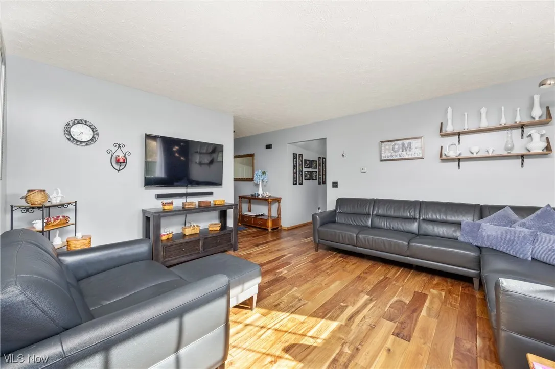 Living area featuring light wood-style floors and a textured ceiling
