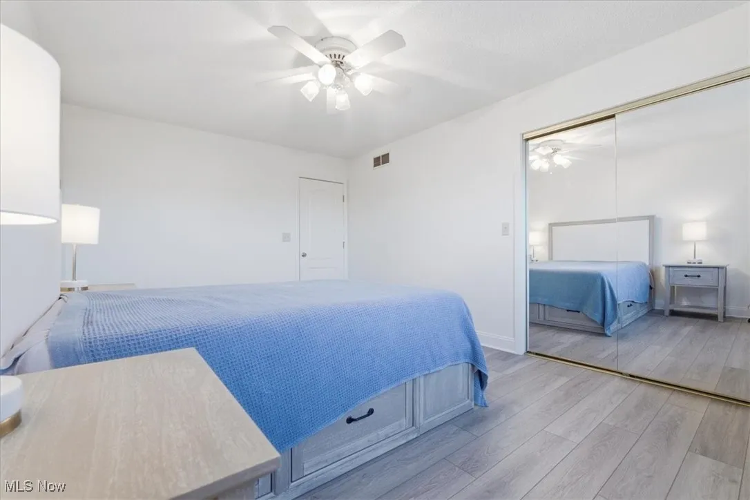 Bedroom with wood finished floors, a ceiling fan, and a closet